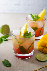 Refreshing summer pink cocktail made with fresh mango juice, ice cubes and mint leaves.