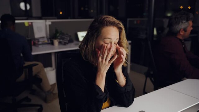 Exhausted caucasian business woman rubbing eyes after long day at work finishing up replying to emails