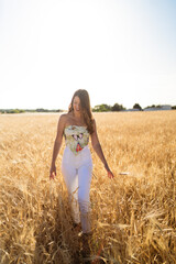 Naklejka na ściany i meble Chica guapa de moda disfrutando en un campo de trigo natural en un dia de primavera verano