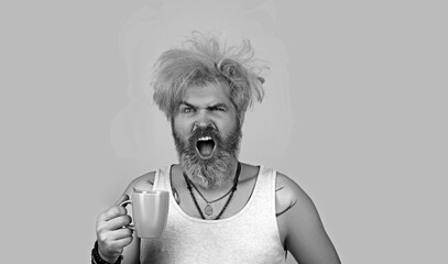 Image of sleepy hipster man 30s with bristle in casual t-shirt drinking coffee.