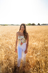 Fototapeta na wymiar Chica guapa de moda disfrutando en un campo de trigo natural en un dia de primavera verano