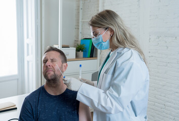 Doctor testing scared adult man for coronavirus infection performing nasal swab, PCR COVID-19 test