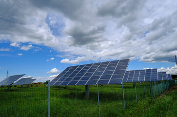 solar panels on a field across the dramatic sky. Solar energy industry. Alternative energy