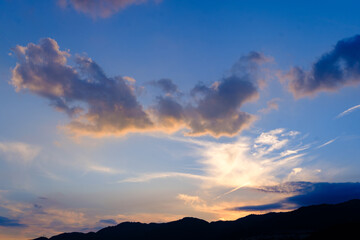 日の入り前の六甲山。西の空と雲がオレンジ色に染まるマジックアワー。高層ビルがシルエットで浮かぶ。１日の終わり。