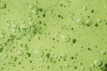 Cosmetic texture with bubbles on pastel green background. Cleanser, shampoo, wash - liquid soap, shower gel, hyaluronic acid, serum. Cosmetics banner