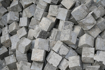 Pellet with  many small granite block cobblestone paving stones, stacked, ready to be used on a construction site, a road and sidewalk renovation site. Construction zone.