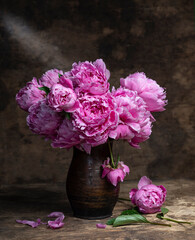 Beautiful bouquet of pink peonies in vase on a wooden table