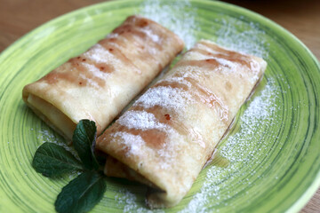 Green plate with stuffed pancakes