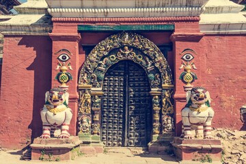 Wooden temple gate guarded by religious deities.