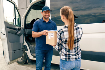 Smiling courier handing a package to a woman
