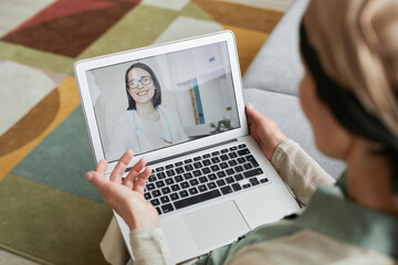 High angle view at woman talking to young female doctor on laptop screen by video chat, copy space
