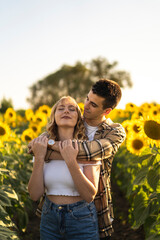 Pareja de jovenes en un campo de girasoles
