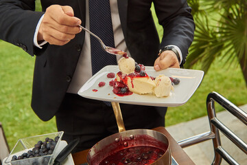 Chef’s Hands Just Finishing a Slice of Cheesecake