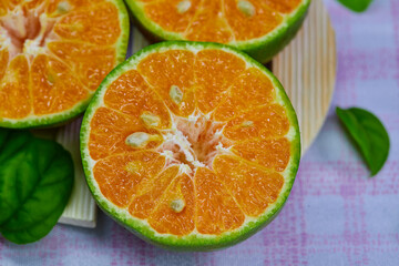 Naklejka na ściany i meble closeup cut of half tangerine isolated on the wooden plate