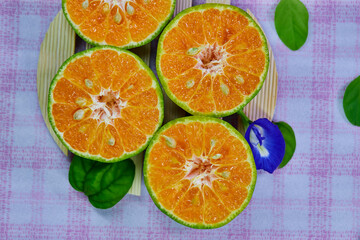 closeup cut of half tangerine isolated on the wooden plate