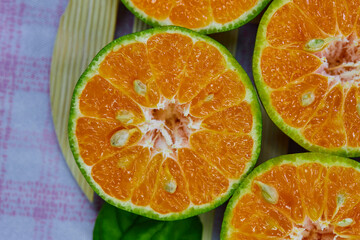 closeup cut of half tangerine isolated on the wooden plate