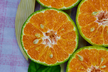 Fototapeta na wymiar closeup cut of half tangerine isolated on the wooden plate
