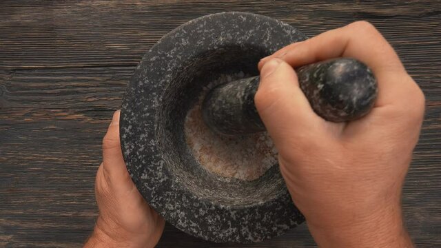 The top view of spices and peppers in the grey stone mortar