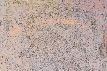 Dots and spots of rust on the red painted metal wall.  Bloated peeling cracked paint.
