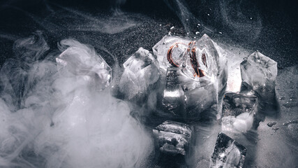 Rings frozen in ice with water and smoke on black background