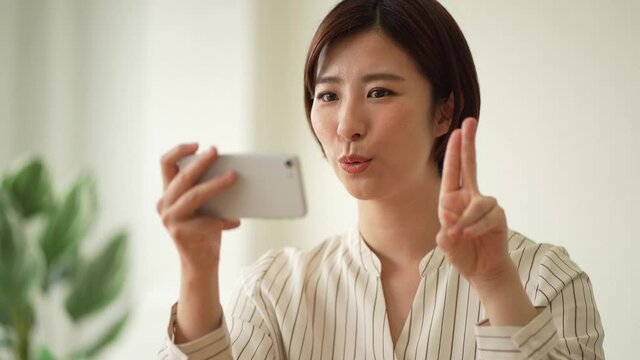 A woman studying sign language finger letters on her smartphone 