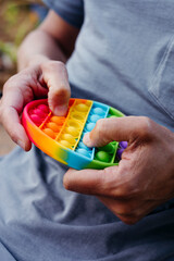 man pops some bubbles of a destressing toy