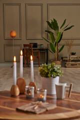 White candle and coffee style on the wood table, decorative working desk background with lamp concept.