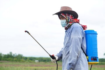Asian farmer uses herbicides, insecticides chemical spray to get rid of weeds and insects or plant disease in agricultural land. Cause air pollution. Environmental , Agriculture chemicals concept. 