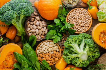 Seasonal abundance of vegetables, herbs, nuts and cereals on a wooden background, top view.