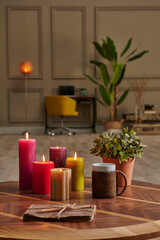Colorful candle close up concept with coffee wicker glass on the wooden desk, decorative working table computer and chair lamp background.