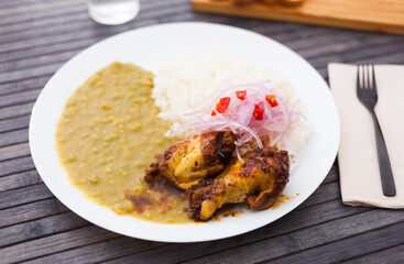 traditional Peruvian dish. chicken wings with pea puree, rice and pickled onions