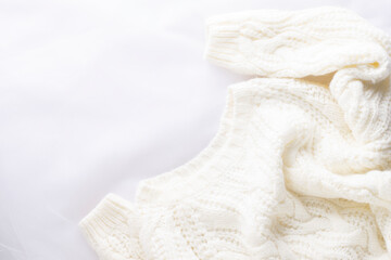 White knitted sweater on a white background with copy space.