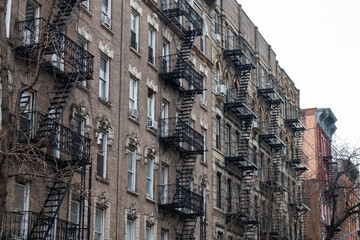 Fototapeta na wymiar Row of Old Generic Apartment Buildings with Fire Escapes in the East Village of New York City