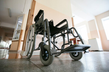 A wheelchair against the background of an empty hospital corridor.