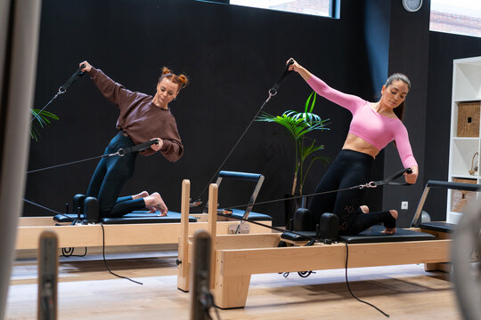 Female athletes exercising on pilates reformers
