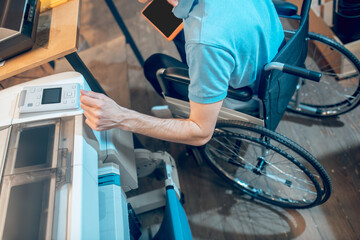 Hand of man on wheelchair near copy machine