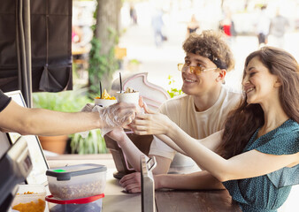 Happy attractive young couple romantically eating a fresh pizza outdoors.