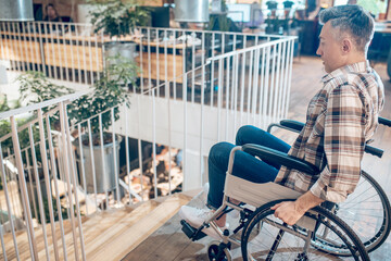 Profile of frightened man on wheelchair near steps