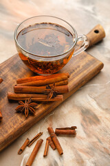 Cup of hot tea with cinnamon on color background