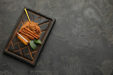 Cinnamon oil, sticks and powder on grey background