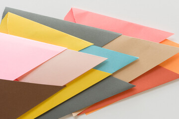 triangle-shaped folded construction paper background - arrows pointing right in pink sand yellow grey blue brown red on white