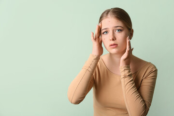 Teenage girl with acne problem on color background