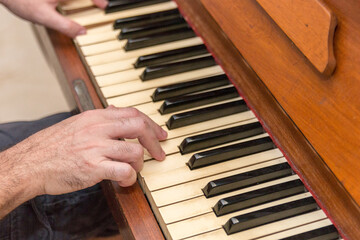 Fototapeta premium hands of a white man playing the piano in Rio de Janeiro.