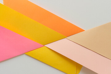 triangle-shaped folded construction paper backgrounds in orange yellow pink and sand