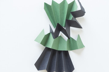 abstract construction paper zig-zag objects or fans isolated on white in green and black