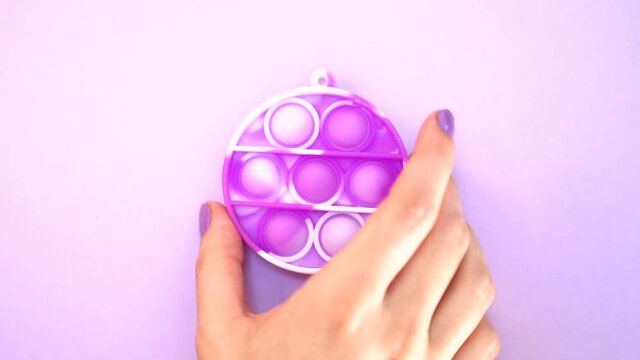Pink pop it fidget toy for kids, female girl teen woman hand popping plastic bubbles