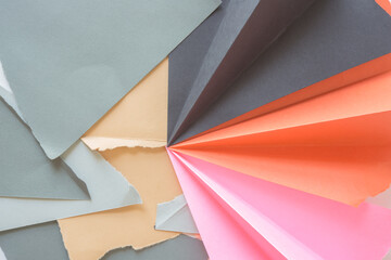 abstract torn folded cut construction paper composition in pink orange black grey and sand - photographed from above