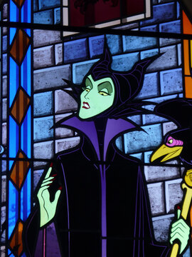 Stained glass window of Maleficent the witch from Disney's Sleeping Beauty movie. Stained glass window of the Disneyland Paris castle. Euro Disney. The magic of Disney. Bad and cruel character.