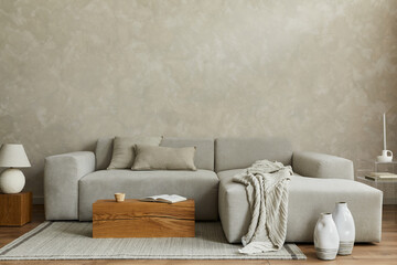 Creative composition of stylish modern spacious living room with grey sofa, wooden cubes, pillows,...
