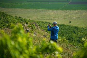 Fototapeta premium Man Taking Pictures with Smartphone in Nature